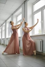 Two ballet dancers rehearsing moves in the hallway