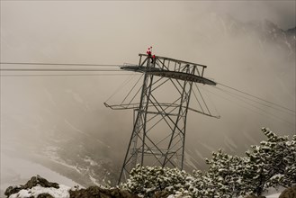 Cable car technicians working in bad weather conditions, Nebelhorn cable car near Oberstdorf,