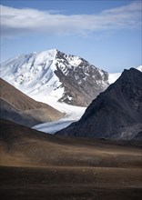 Autumnal plateau with brown grass, glaciated and snowy peaks, Sary Tor Glacier, Ak Shyrak