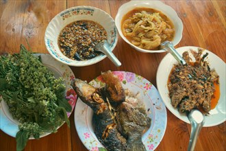 Overhead view of an authentic traditional thai meal of grilled catfish or pla duk yang, sour bamboo