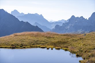 Mountain lake in front of mountain landscape, silhouettes of rocky mountain peaks, Luggauer Toerl,