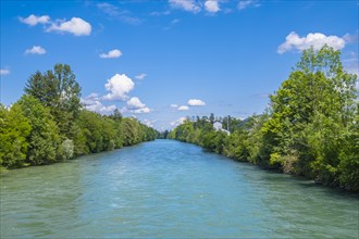 A calm river surrounded by green trees under a blue sky with fluffy clouds, Emmen, Lucerne,