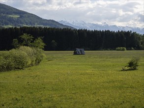 Meadow with hay barn, snow-covered mountain peaks behind, near Irdning, Ennstal, Styria