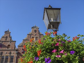 View of historic buildings and an old lantern against a clear blue sky, surrounded by colourful