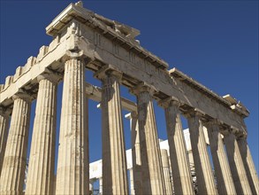 The Parthenon with its imposing columns under a clear blue sky, historic columns and ruins at an