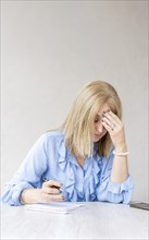 Tired woman touching forehead having headache migraine. Vertical shot