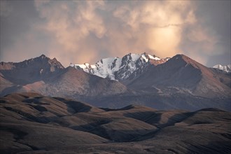 Snow-covered and glaciated mountain peaks at sunset, Issyk Kul, Kyrgyzstan, Asia