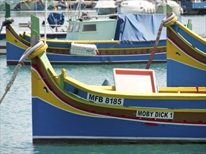 Several colourful fishing boats lying quietly in the harbour, many colourful fishing boats in a