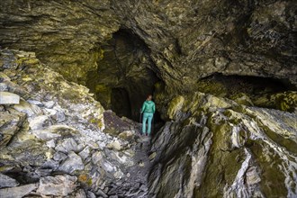 Hiker explores Obstans ice cave in Alta Pusteria, Carnic Alps, East Tyrol, Austria, Europe