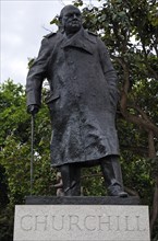 Bronze statue of Churchill with a walking stick in a park, London, England, Great Britain
