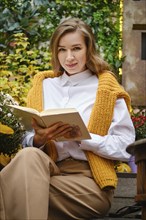 Young playful woman with a book outdoor