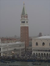Campanile of Venice, surrounded by historic buildings, in foggy twilight, church towers and