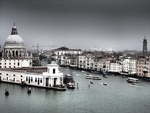 A view of the canals of Venice with historic buildings and boats on the water on a cloudy day,