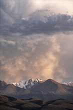 Snow-covered and glaciated mountain peaks at sunset, Issyk Kul, Kyrgyzstan, Asia