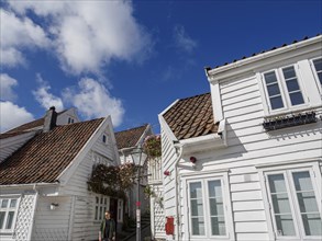 White wooden houses with red tiled roofs and lanterns under a blue sky, white wooden houses with