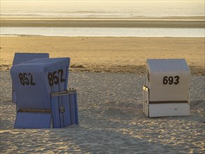 Blue and white beach chair on sand at the beach, sunset, sunset at a quiet beach with many