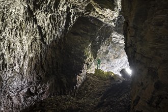 Hiker explores Obstans ice cave in Alta Pusteria, Carnic Alps, East Tyrol, Austria, Europe