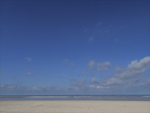 Spacious beach under a clear blue sky with a view of the sea, wide sky on the lonely North Sea