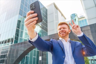 Businessman gesturing success while taking selfie standing in the city