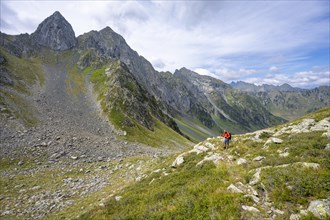 Mountaineer on a hiking trail at a saddle, pointed rocky mountain peaks Letterspitze and Steinwand