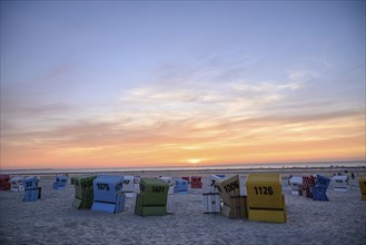 Several colourful beach chairs on the beach at sunset, many colourful beach chairs on a warm summer