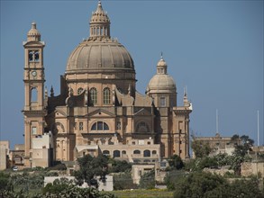 A large baroque basilica with a dome and an integrated clock tower made of sandstone, stand-alone