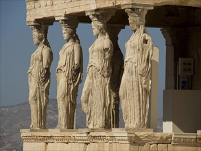 Statues of caryatids replacing columns on the Acropolis, historical columns and ruins on an ancient
