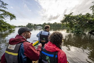 Tourists in a rowing boat on the Tortuguero River, watching animals in the rainforest, Tortuguero