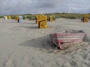 Empty boat on the beach with surrounding beach chairs and dunes, under a cloudy sky, colourful