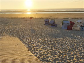 Beach with beach chairs and a sign in the sunset, peaceful and quiet atmosphere at golden hour,