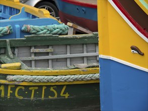 Close-up of colourful fishing boats lying next to each other in the harbour, many colourful fishing