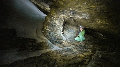 Hiker explores Obstans ice cave in Alta Pusteria, Carnic Alps, East Tyrol, Austria, Europe