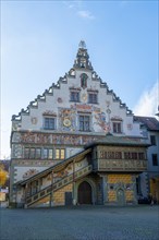 Detailed view of a historic building with frescoes and a bay window under a clear blue sky, Lindau