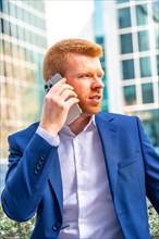 Vertical photo of the close-up of a businessman looking aside while talking to the mobile sitting