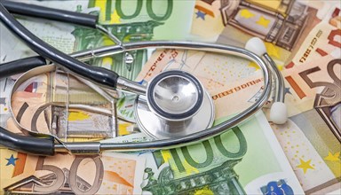 Symbol photo, a stethoscope and medical instruments on a surface of euro notes, money, AI