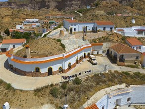 View of a Spanish village in a dry environment with white and orange houses, aerial view, cave