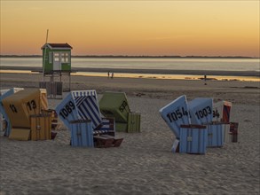 Sunset on the beach with colourful beach chairs and green beach hut, beautiful sunset on the beach