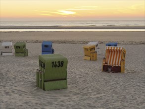 Beach chairs on the sandy beach during sunset, sea in the background, sunset on a quiet beach with