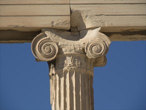 Single marble capital and its details in close-up against a clear blue sky, historical columns and