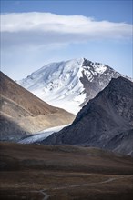 Autumnal plateau with brown grass, glaciated and snowy peaks, Sary Tor Glacier, Ak Shyrak