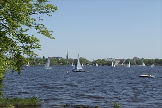 Symbolic picture weather, leisure activity, summery spring, sailboats and pedal boats against a