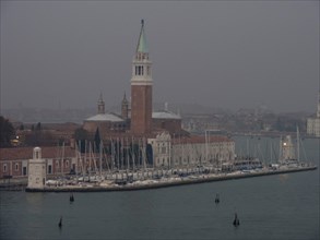 San Giorgio Maggiore church in Venice with boats in the foreground and foggy atmosphere in the