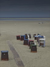 Group of beach chairs on empty, cool beach, cloudy sky and calm atmosphere, beach chairs and beach