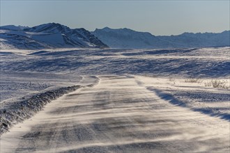 Snow drifts on gravel road in winter, Dalton Highway, Brooks Range, Alaska, USA, North America
