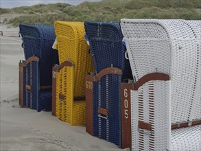 Beach chairs in different colours and numbers on a deserted beach, colourful beach chairs on the