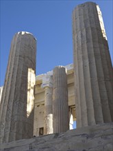 Close-up of several ancient columns in front of a sunny blue sky, historical columns and ruins at