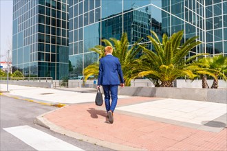 Rear view of an elegant businessman arriving at the block office