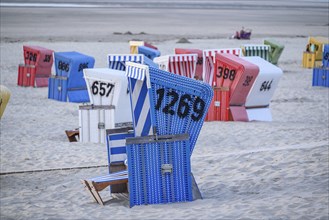 Quiet summer day atmosphere on the beach with colourful beach chairs and soft sand, many colourful