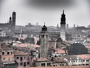 Foggy view over the roofs of Venice with several historic towers, church towers and historic
