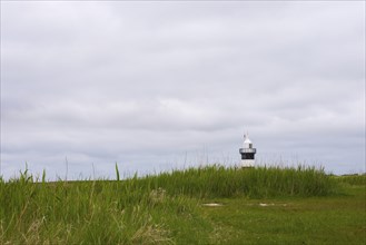 Black and white lighthouse near the North Sea resort Wremen, called 'Kleiner Preusse', behind high